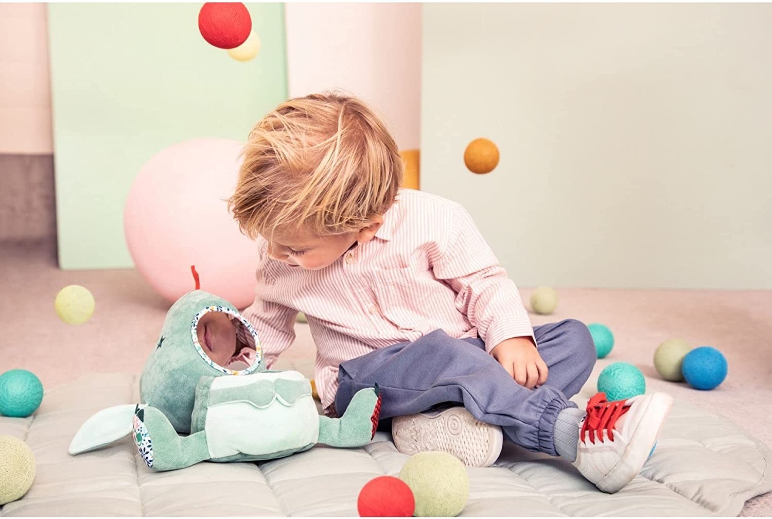 Bebé jugando con el peluche de actividades Joe el Mago Lilliputiens - desarrollo motricidad fina

