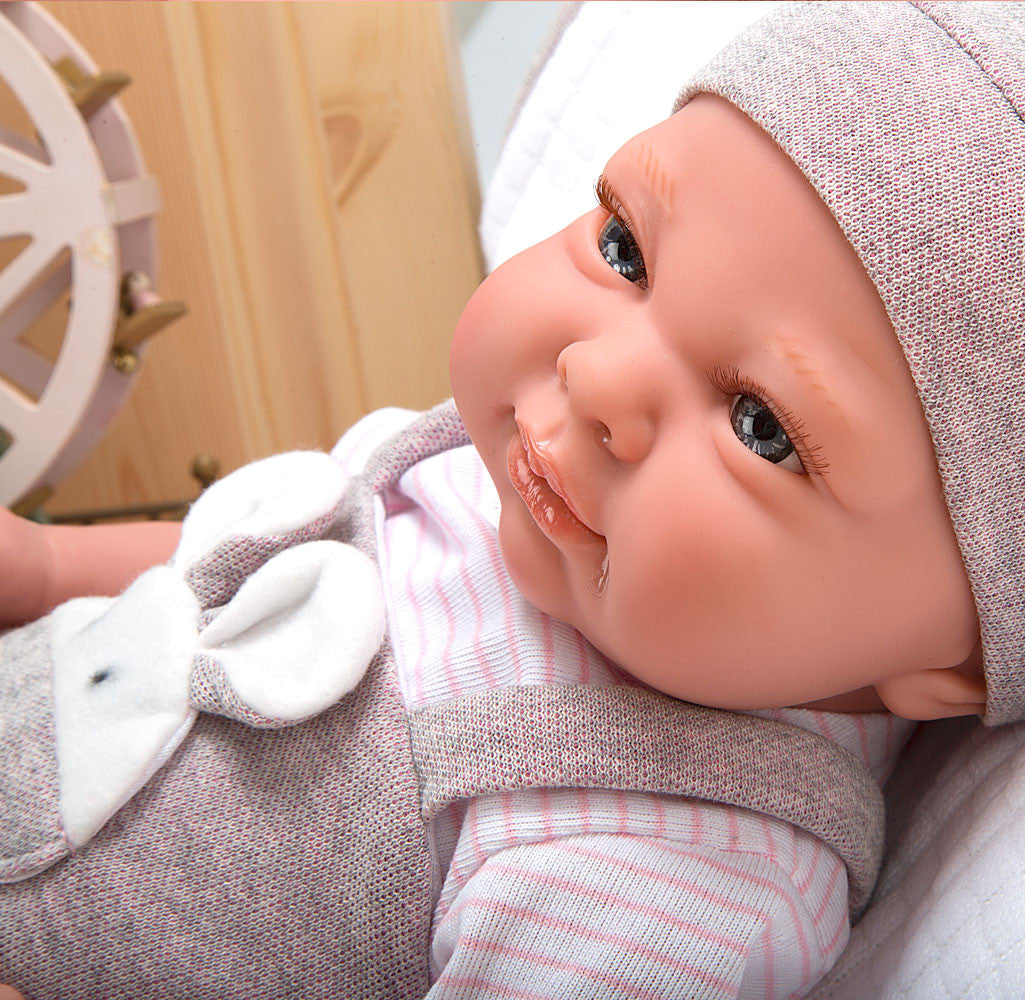 Primer plano realista del rostro de la muñeca con peso Cris de Muñecas Arias con gorrito de punto.