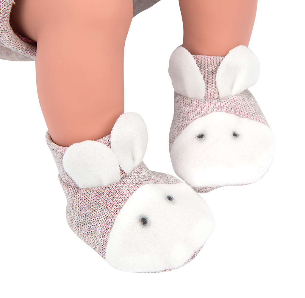 Primer plano de los pies de la muñeca con peso Cris de Arias con patucos de punto lila con pompones.