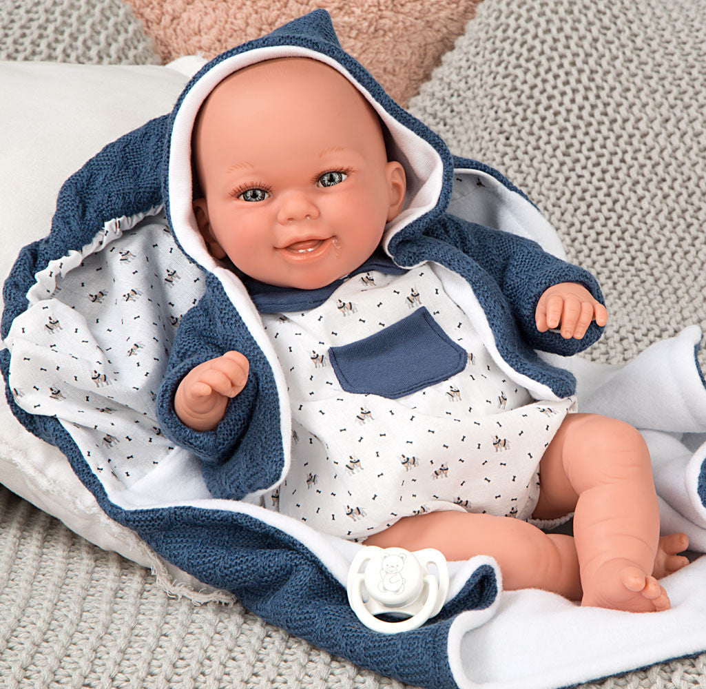 Muñeca con peso Elegance Babyto de Arias vestida con ranita azul con estrellas blancas sobre cojín beige texturizado.