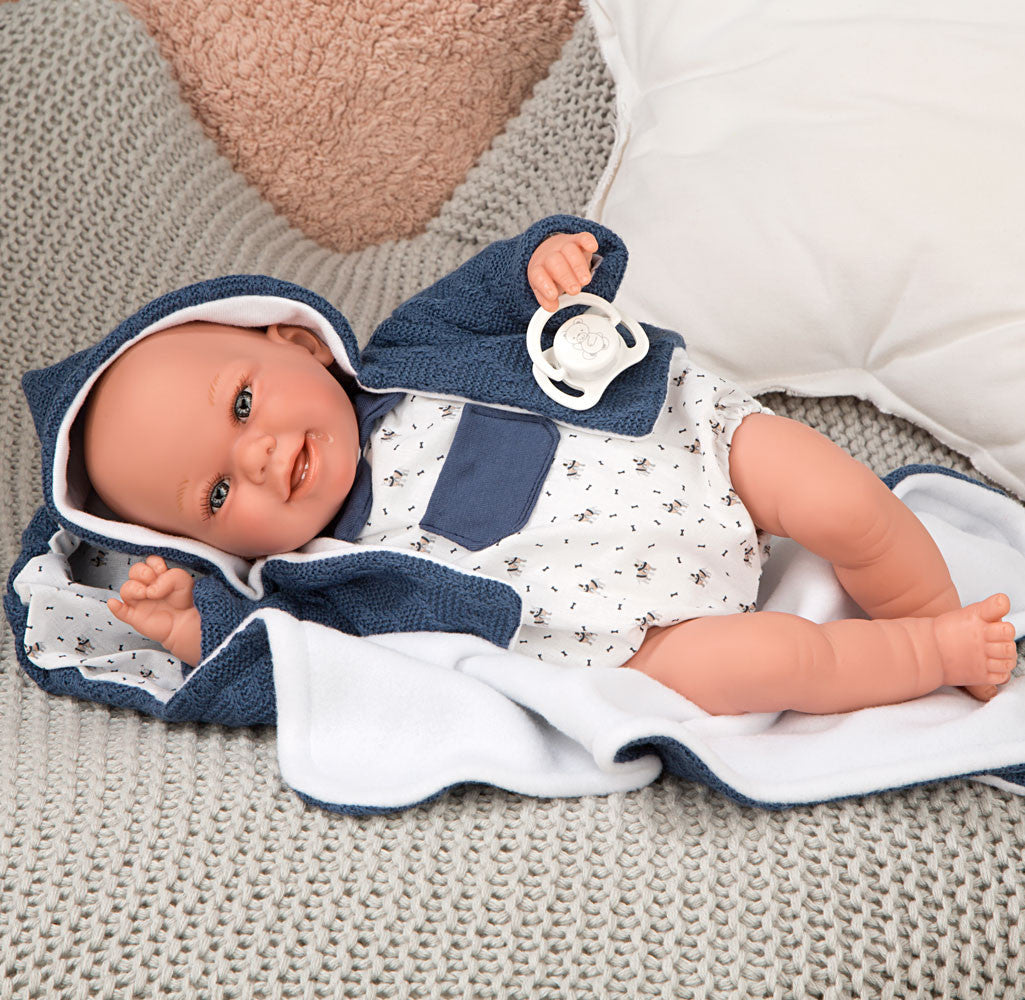 Muñeca con peso realista Babyto Arias con pelele azul tipo ranita, ideal para fomentar un desarrollo real sin pantalla.