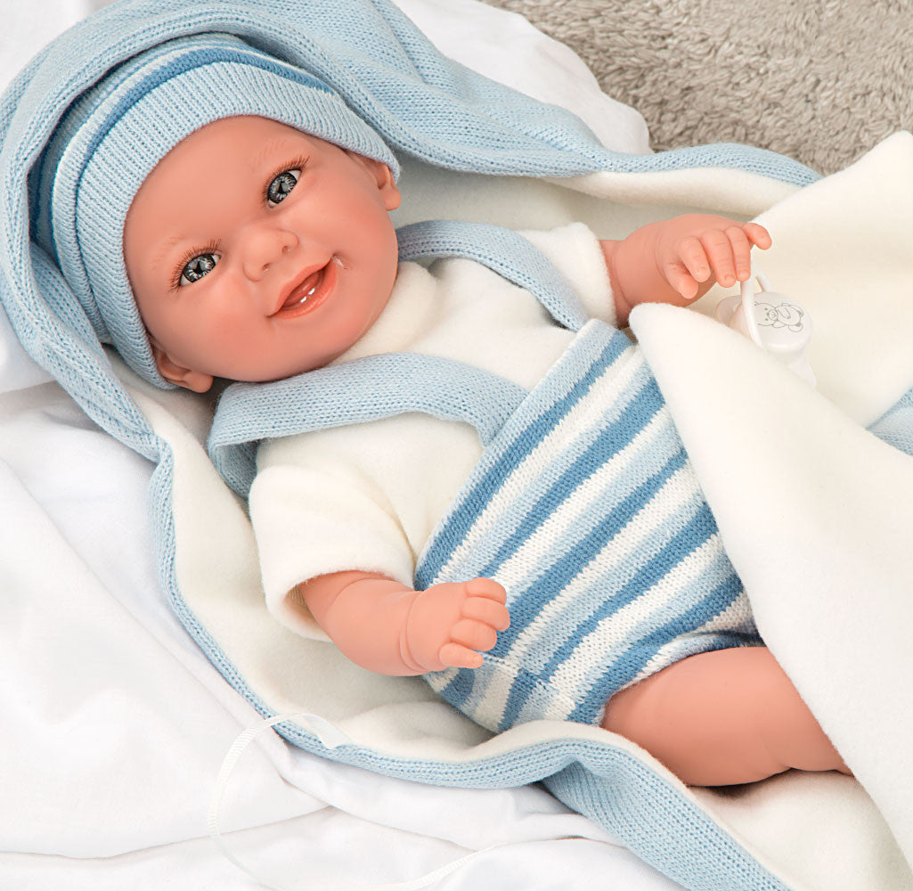 Muñeca con peso Elegance Babyto de Arias vestida con pelele de rayas blancas y azules sobre su cojín a juego.
