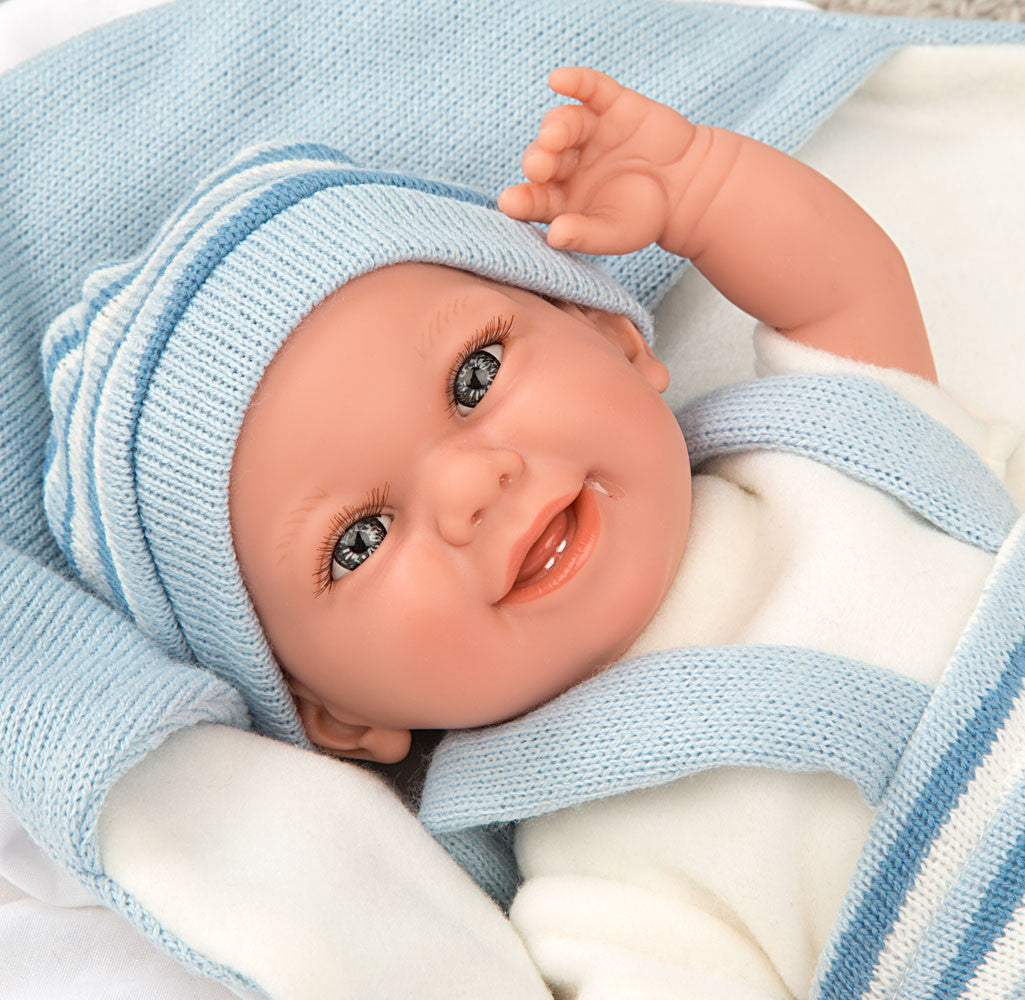 Primer plano detallado del rostro sonriente y los ojos claros de la muñeca con peso Babyto Elegance de Arias.