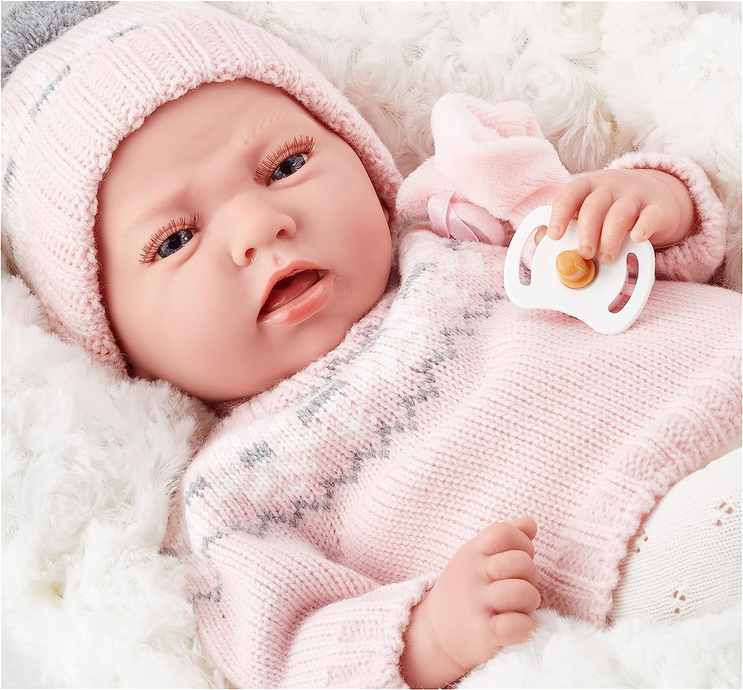 Muñeca Elegance Dafne 40 cm Arias 60592 tumbada sobre el cojin rosa incluido mostrando el conjunto completo