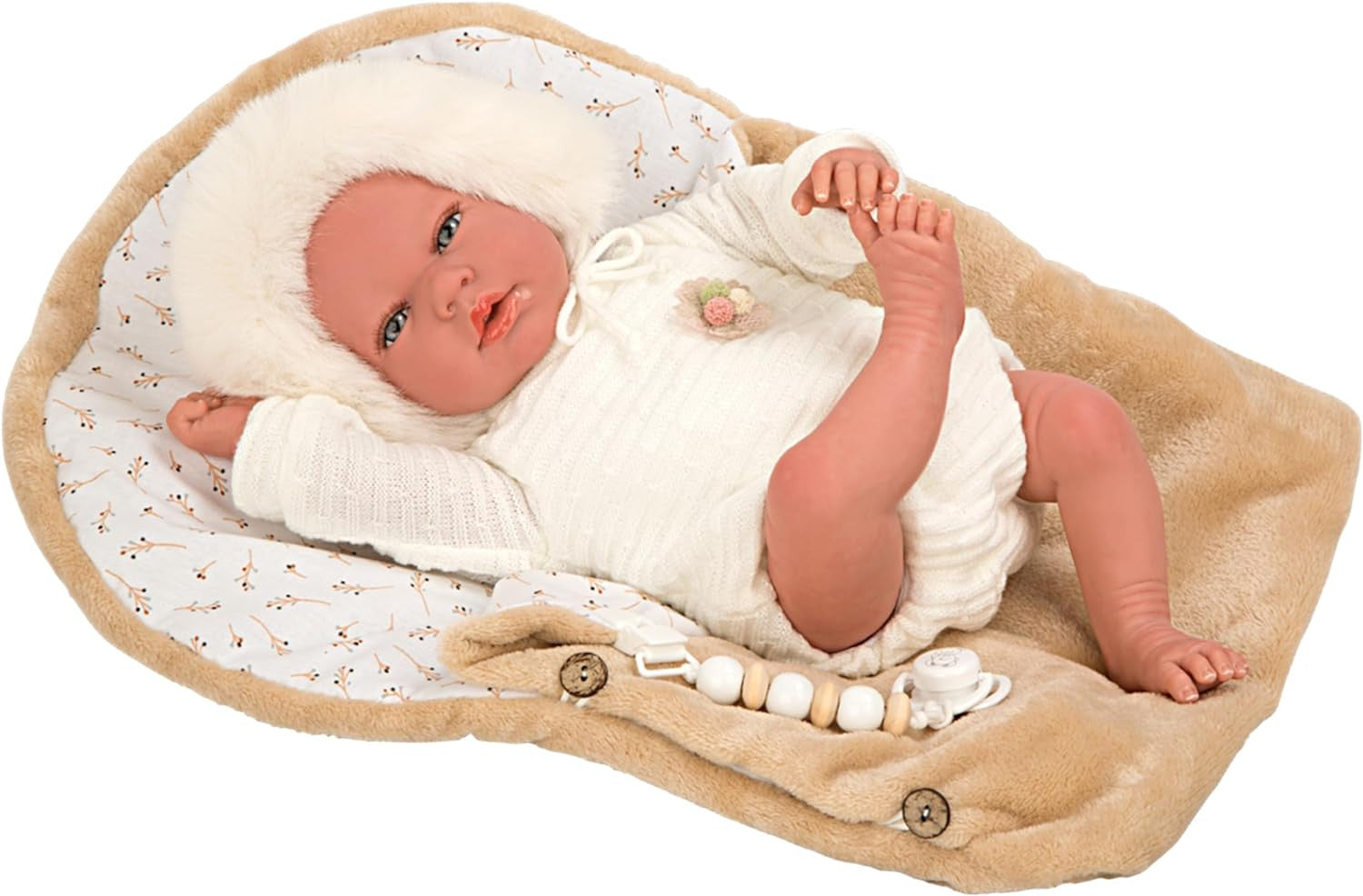 Muñeca Reborn Alejandra de Arias tumbada de espaldas luciendo la capota beige y los lazos artesanales de su conjunto.
