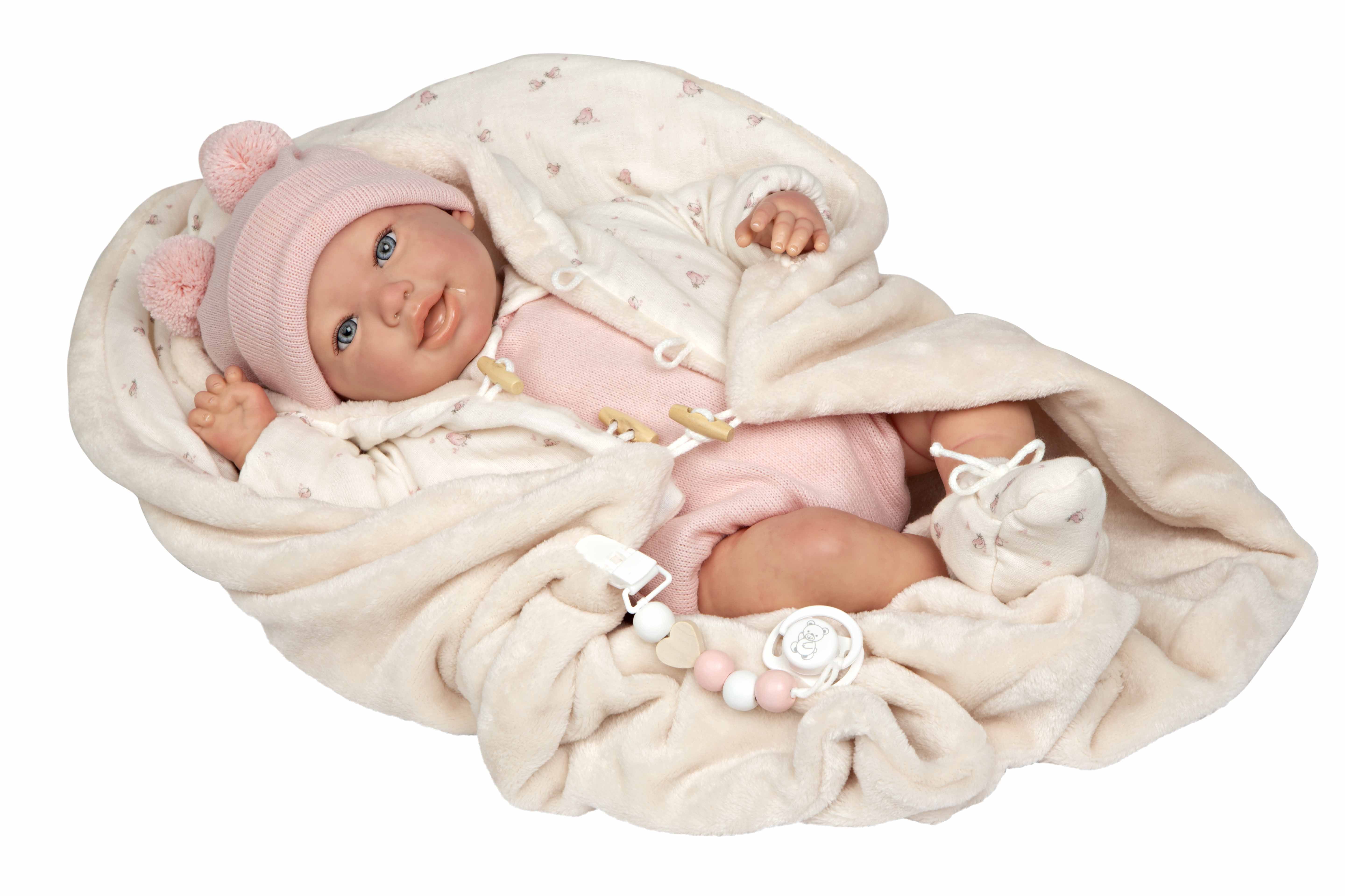 Bebé Reborn realista Elba de Muñecas Arias recostada de perfil junto a su pequeño peluche de oso rosa.
