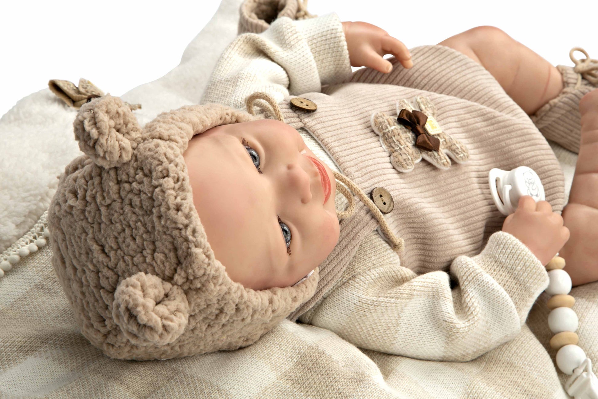 Detalle de perfil del rostro hiperrealista del muñeco Reborn Rubén de Arias mostrando el acabado blando y su gorrito con orejas.