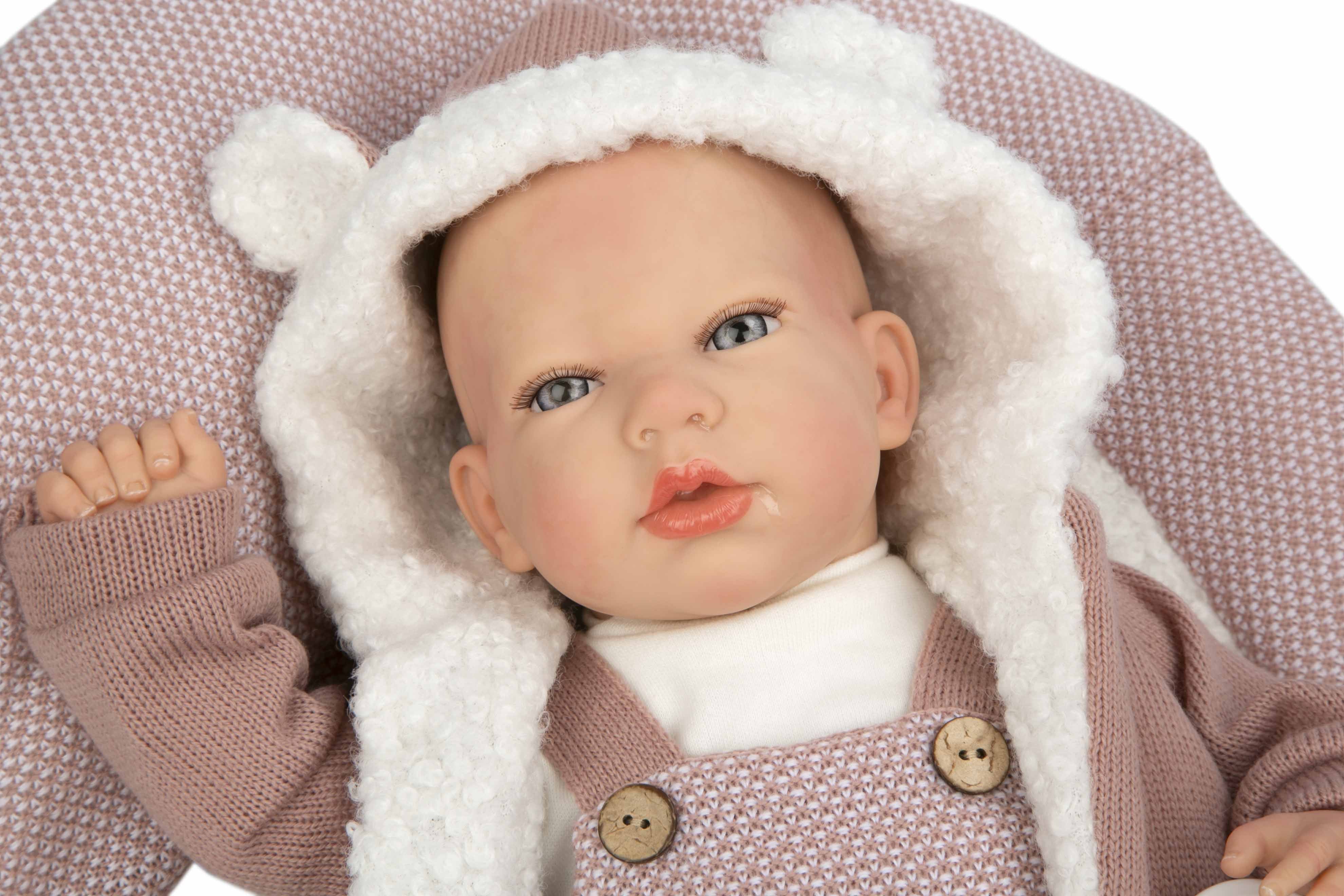 Muñeca Reborn original Gadea de Muñecas Arias recostada luciendo su tierno gorro con orejitas suaves.