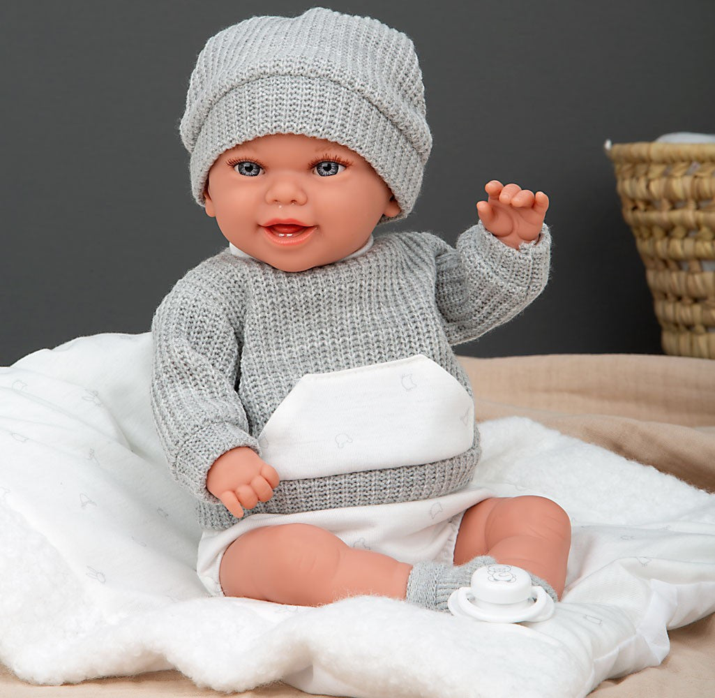 Primer plano cara muñeco bebé Babyto Elegance Arias con gorro gris – expresión realista y detalles de vinilo de alta calidad
