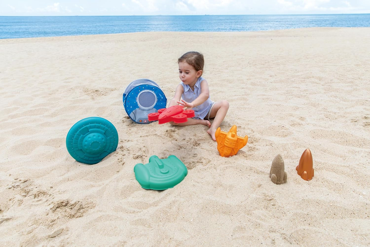 Niño jugando con moldes de arena Hape Naves Espaciales en la orilla – juego sensorial y motricidad fina en la playa desde 18 meses
