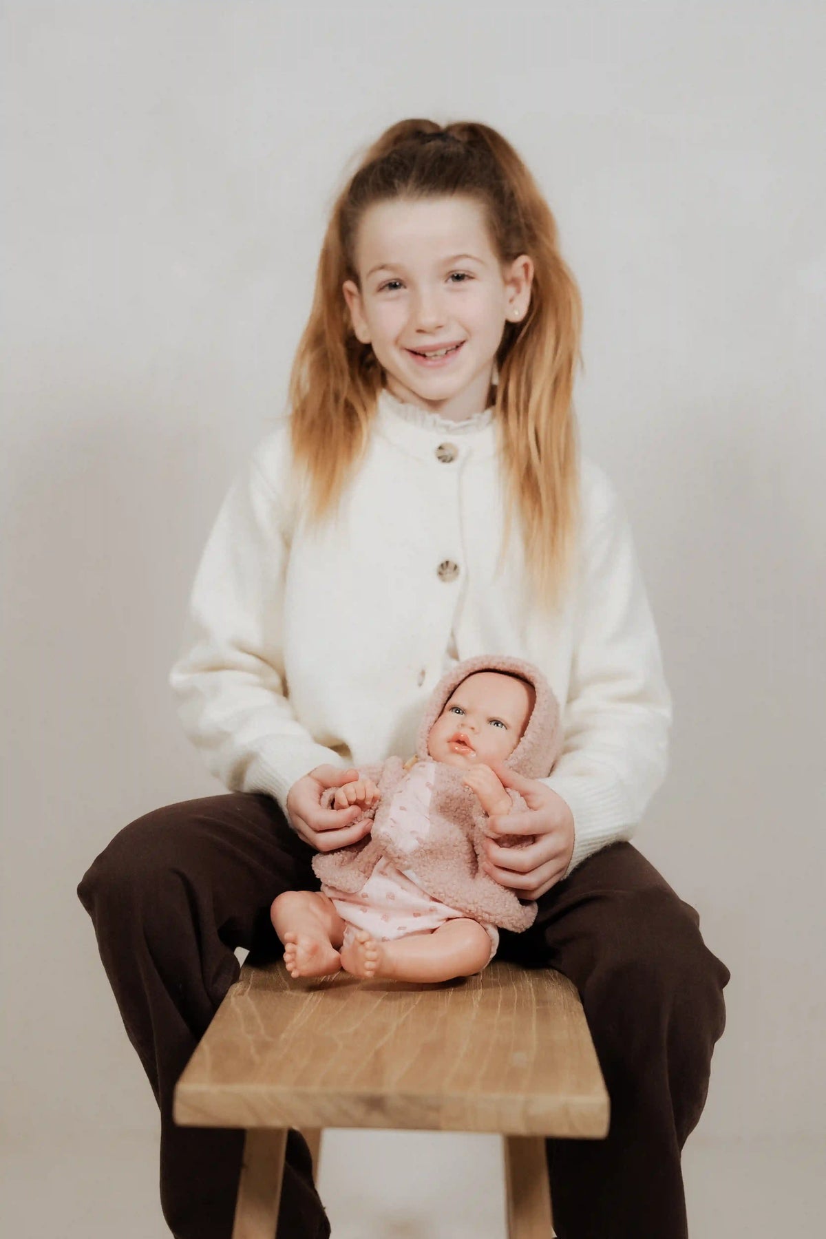 niña sosteniendo la Muñeca Reborn Luna Rosa de Muñecas Arias sentada sobre sus piernas