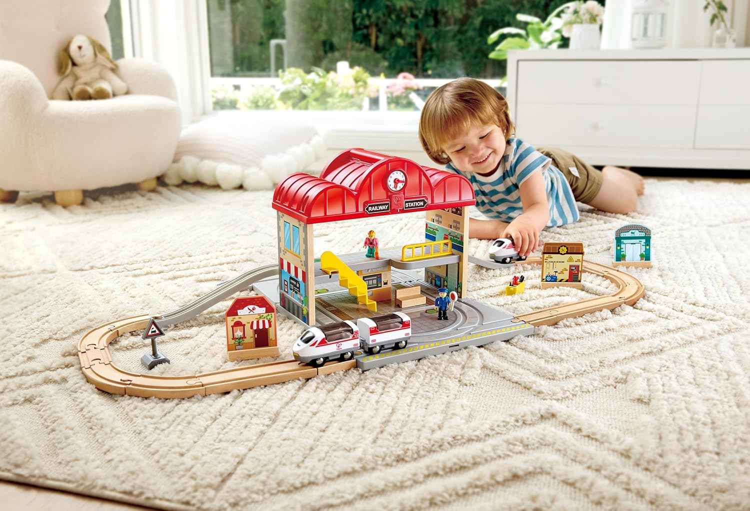 Estación de tren Hape E3877 abierta mostrando almacenamiento y piezas incluidas