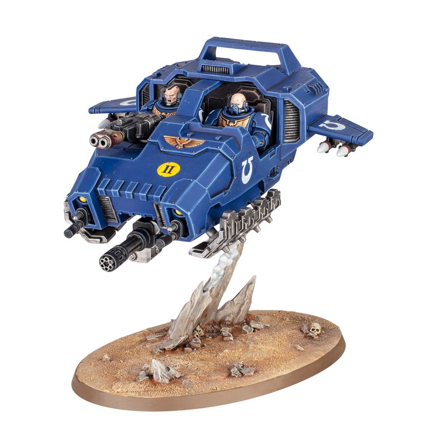 Land Speeder de Warhammer 40,000, miniatura azul de los Marines Espaciales sobre una base ovalada y fondo blanco.