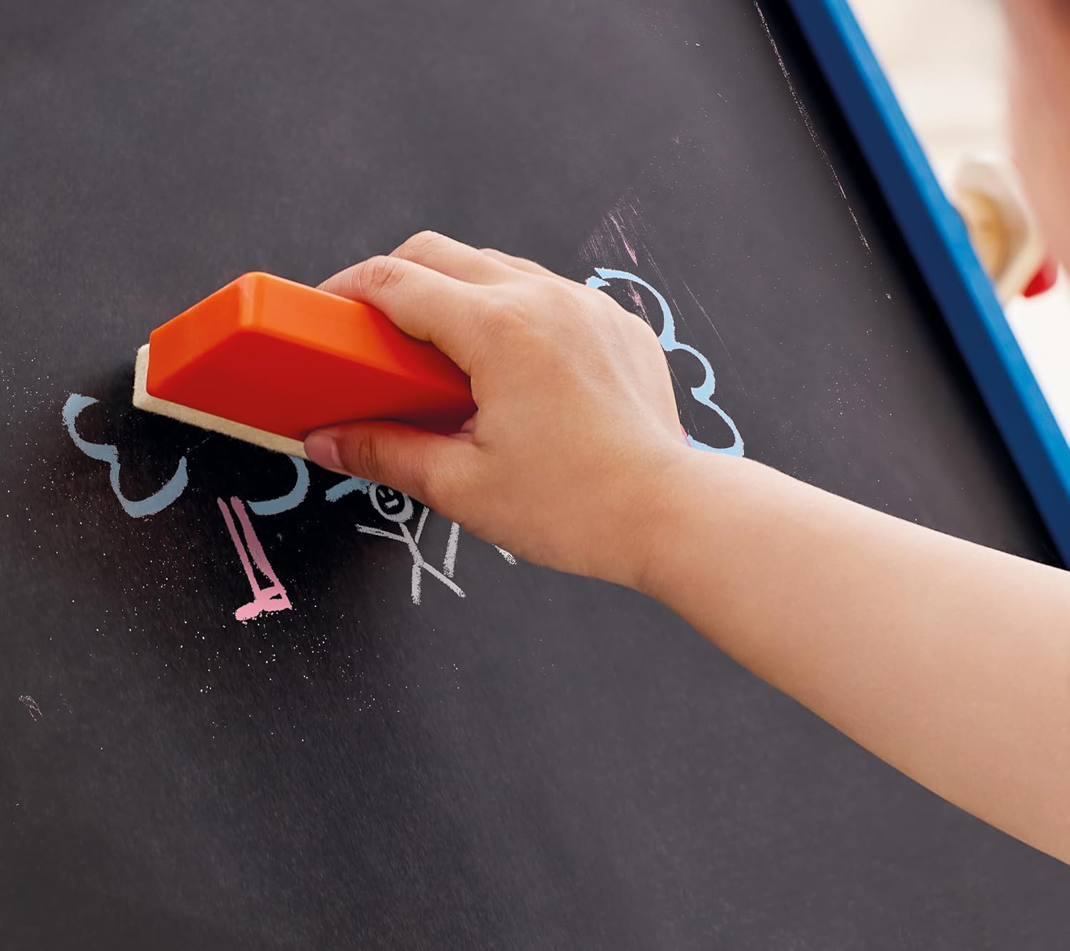 Niño utilizando el estudio de dibujo portátil de madera Hape en exteriores para fomentar la creatividad.