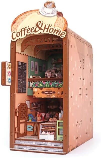  Maqueta soporte de libros Cosy Coffee de Graine Créative, vista frontal y lateral con mostrador, estantes y mesas.