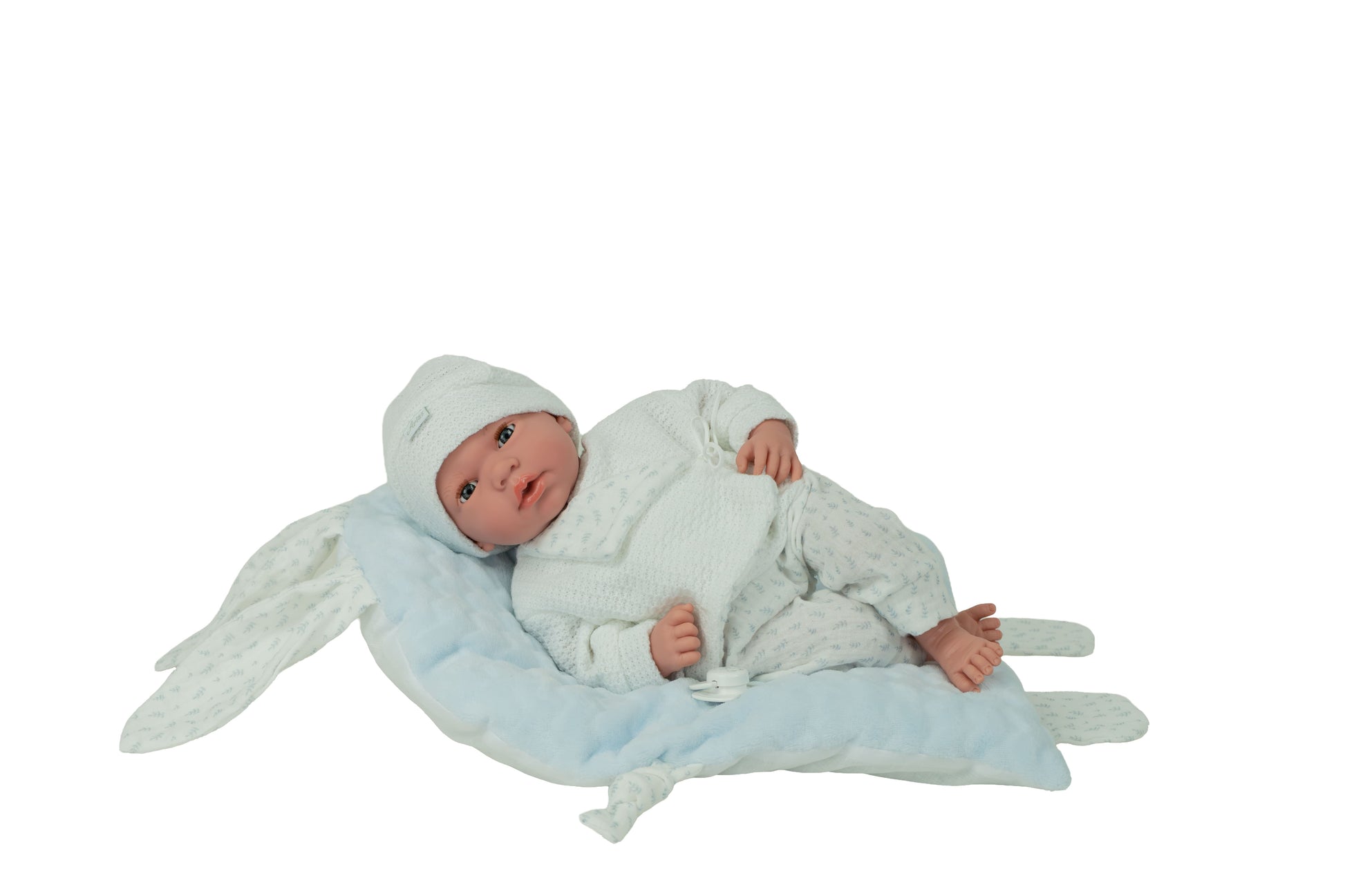 Muñeca bebé Andie Arias 40 cm tumbada sobre cojín azul de orejitas, ropita blanca y azul, cuerpo blando con extremidades de vinilo