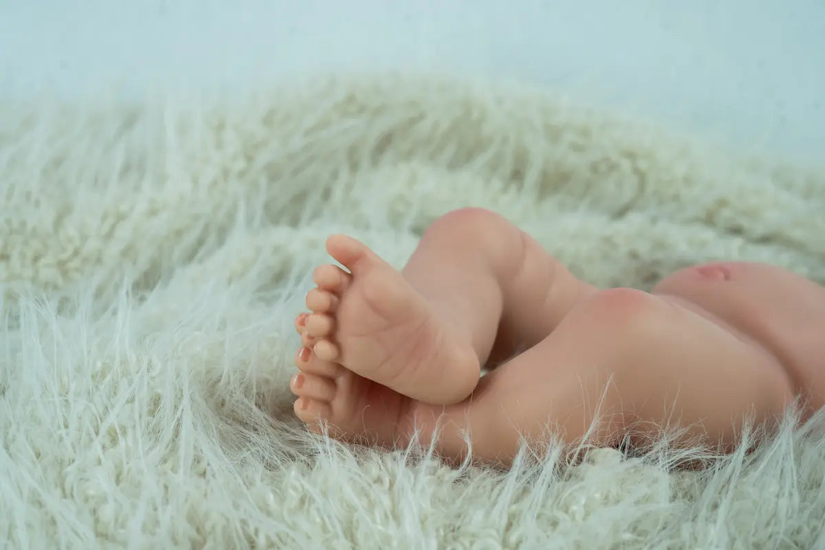 Muñeca Reborn Aitana de Arias 98204 tumbada sobre una manta verde, con detalle de su postura y tamaño.