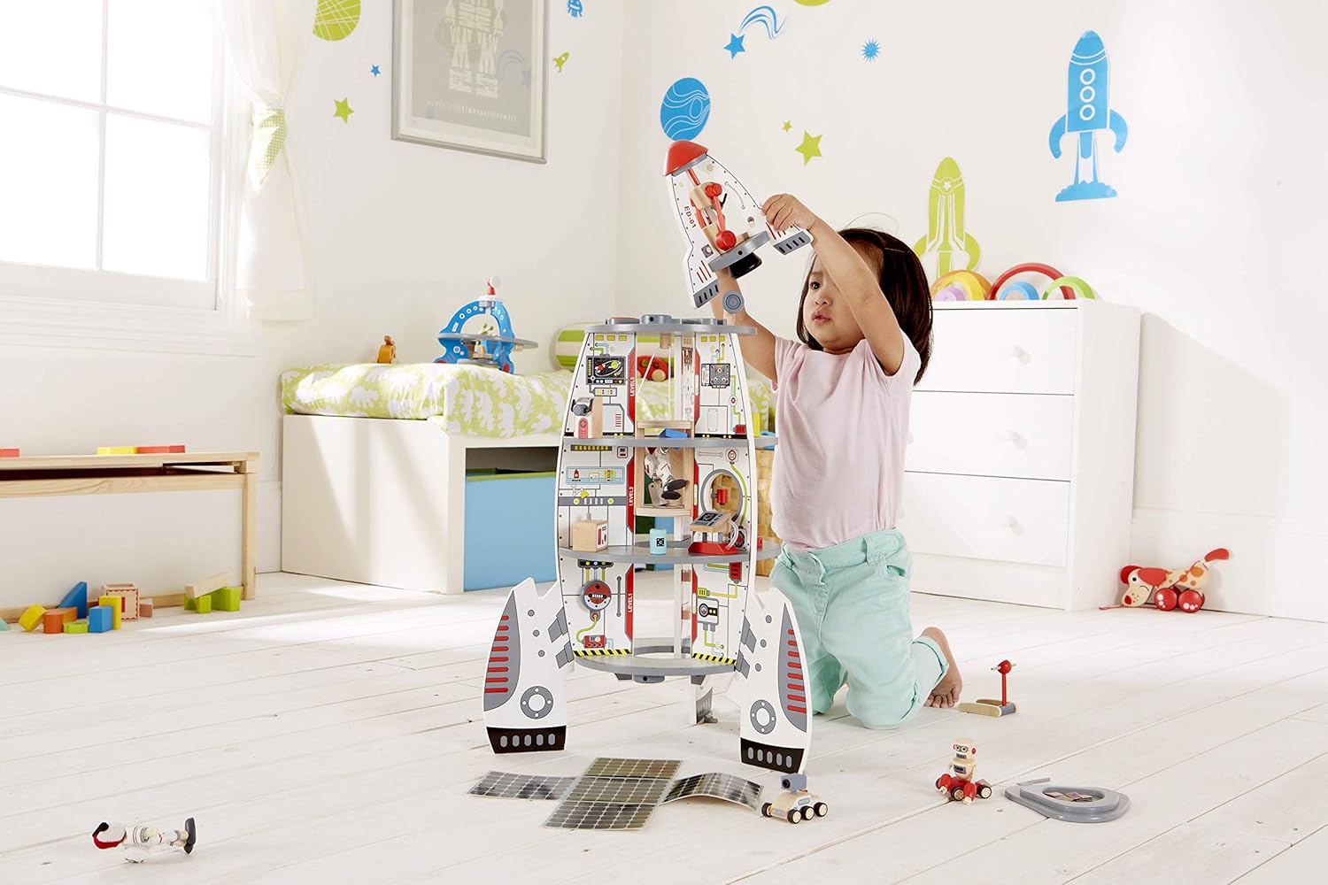 Niño jugando con el cohete espacial HAPE, juguete de madera para juego simbólico y cooperativo