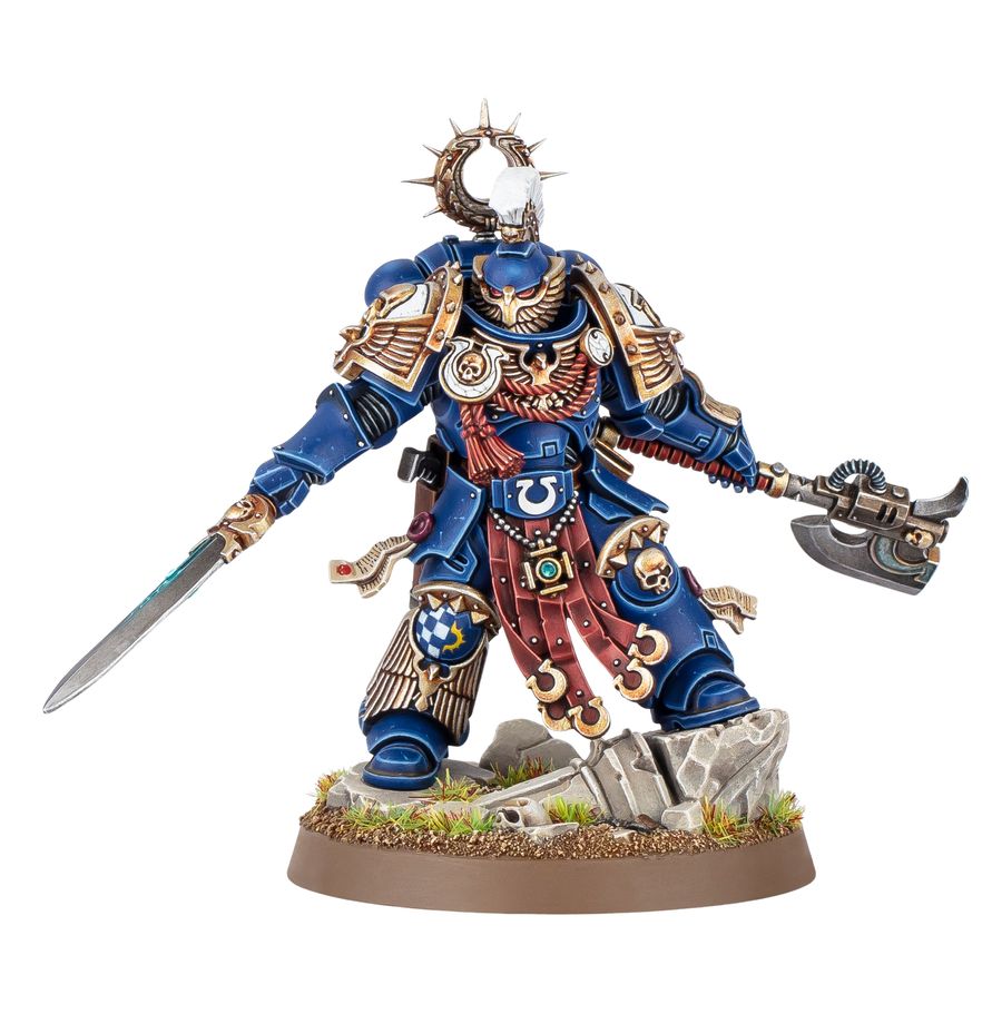 Kaius Konorius Warhammer 40.000, miniatura Ultramarines pintada con armadura azul y capa roja, blandiendo espada y hacha de combate.