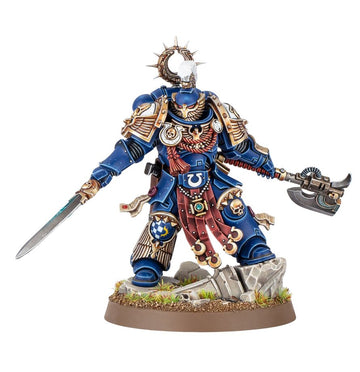 Kaius Konorius Warhammer 40.000, miniatura Ultramarines pintada con armadura azul y capa roja, blandiendo espada y hacha de combate.